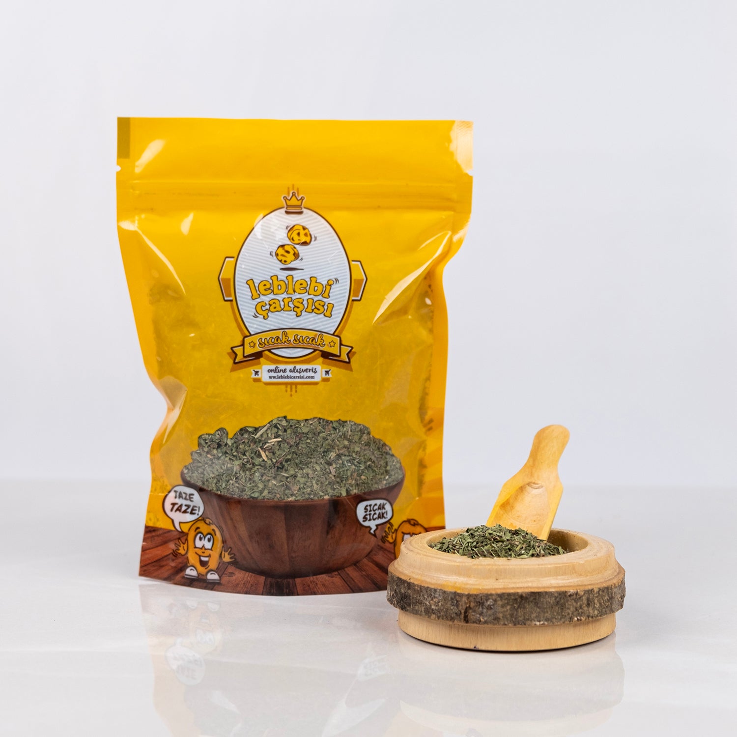 İnce elenmiş, kurutulmuş doğal nane yaprakları beyaz zeminde yığılmış şekilde sergileniyor. Taze renkli ve yoğun kokulu geleneksel baharat görüntüsü.