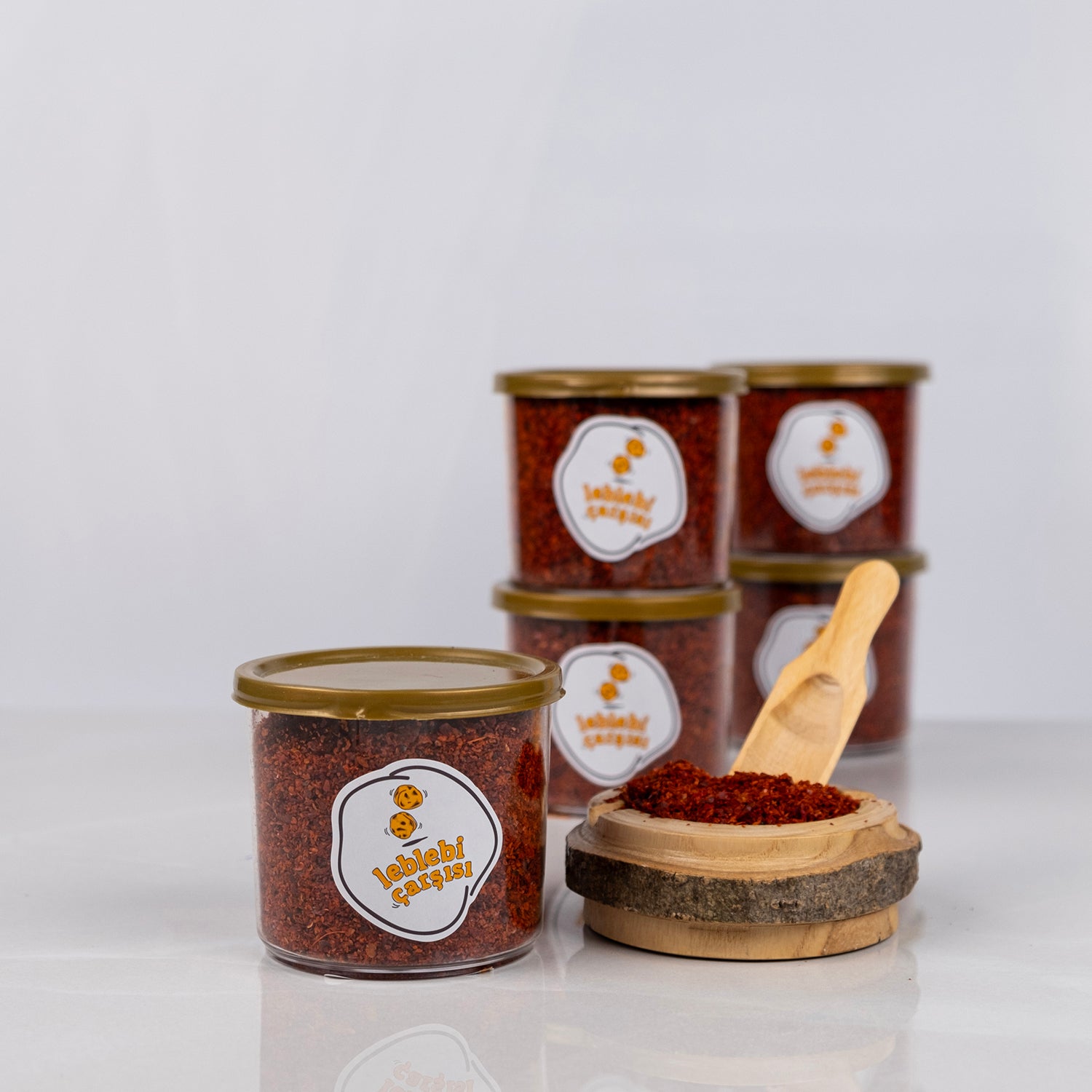 Doğal pul biber, katkısız ve yoğun kırmızı renkli acı baharat ürünü olarak sade zeminde sergilenmiş.